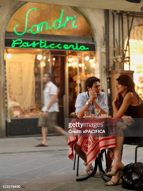 young couple sitting at outdoor table - umbria stock pictures, royalty-free photos & images