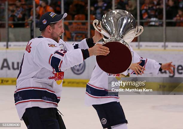 Michael Wolf of Muenchen celebrates with the trophy after winning the DEL playoffs final game four between Grizzlys Wolfsburg and Red Bull Muenchen...