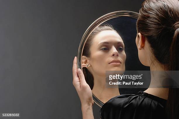 woman checking her reflection in silver serving platter - spiegel stock-fotos und bilder