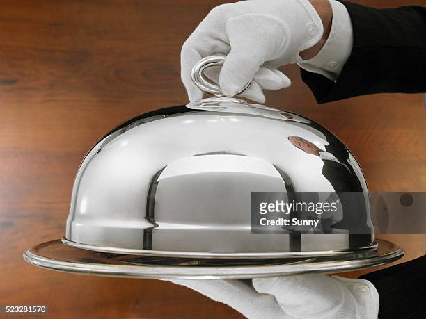 waiter carrying serving tray - zilverkleurige handschoen stockfoto's en -beelden