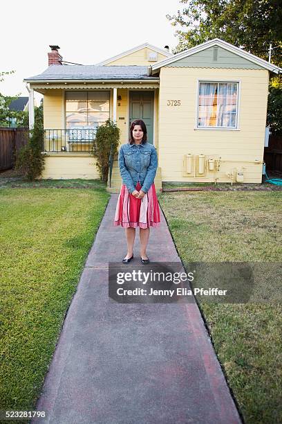 woman standing in front of house - double denim stock-fotos und bilder