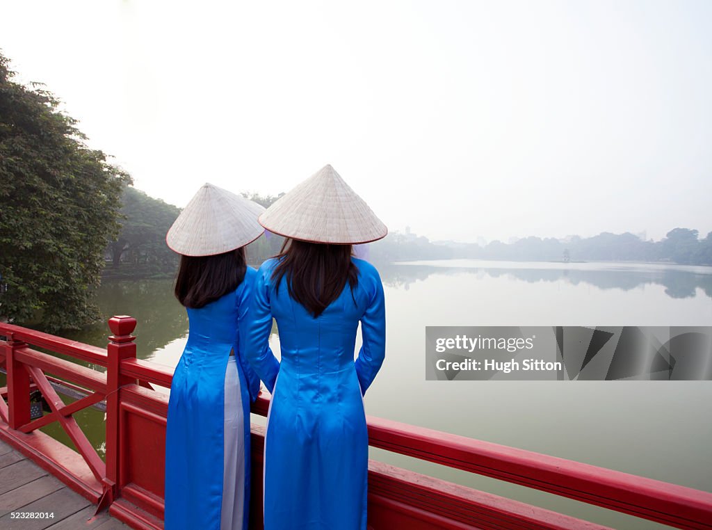 Vietnamese women in traditional costume. Ho Kiem Lake. Hanoi.