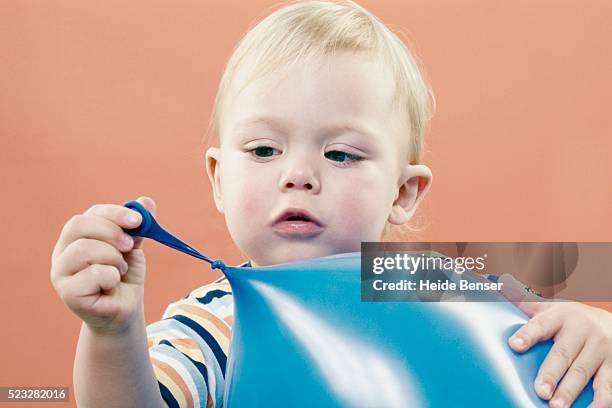 young boy playing with balloon - alleen jongens stockfoto's en -beelden