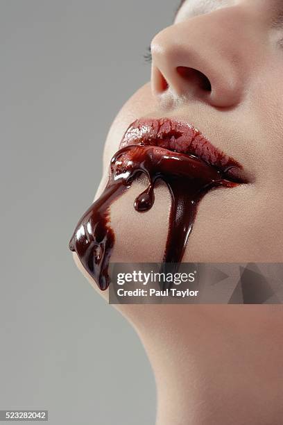 woman with chocolate syrup dripping from mouth - chocolate face stock pictures, royalty-free photos & images