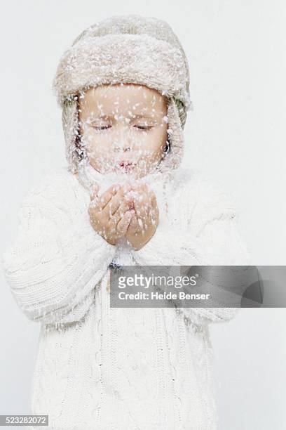 young boy playing with snow - schnee pusten stock-fotos und bilder