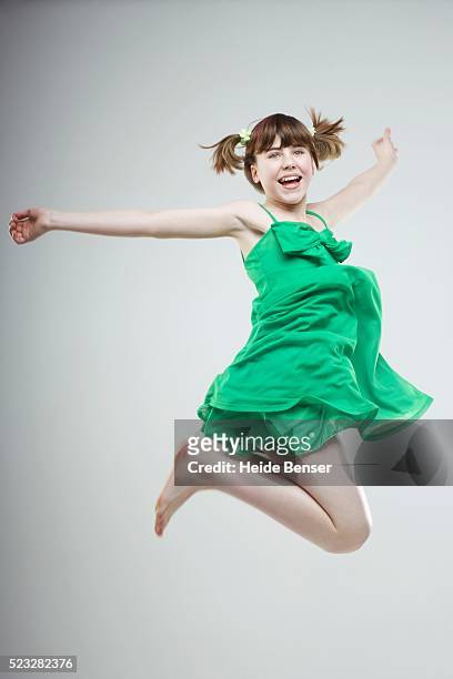 girl jumping for joy - green dress imagens e fotografias de stock