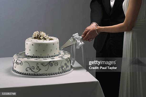 newlyweds cutting their wedding cake - wedding cake foto e immagini stock