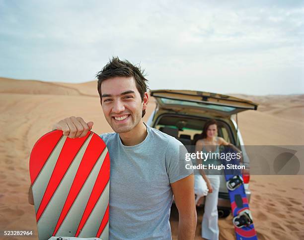 couple on vacations, dubai - sand boarding stock pictures, royalty-free photos & images