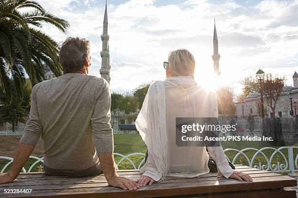 couple watch sunrise over blue mosque, gardens - moschea blu istanbul foto e immagini stock