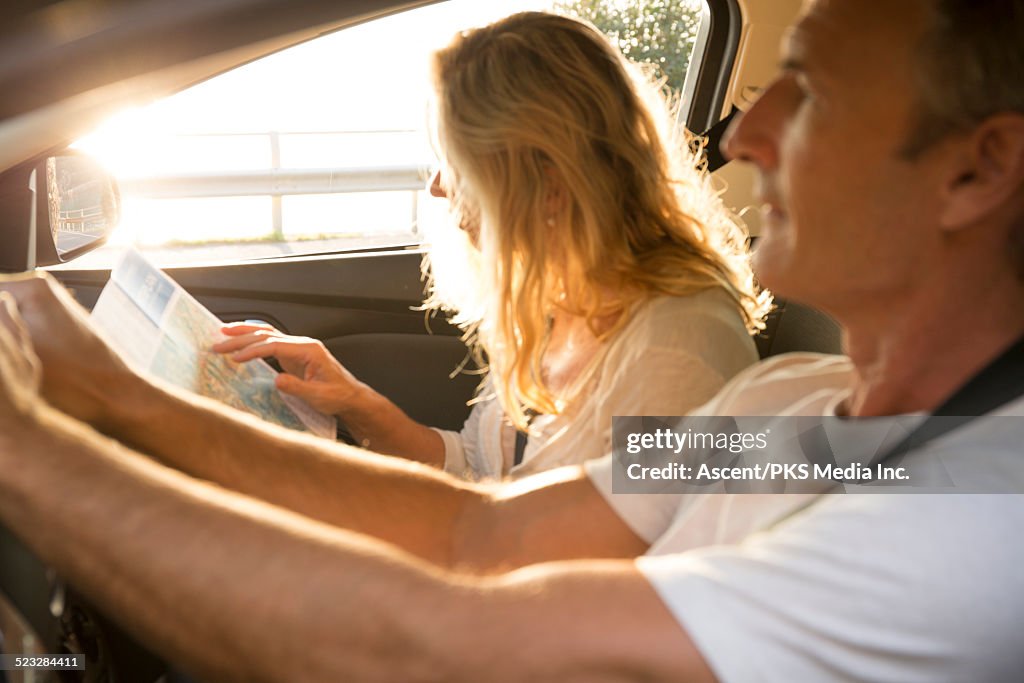 View through car of couple using map, driving