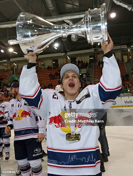 Dominik Kahun of Muenchen kisses the trophy after winning the DEL playoffs final game four between Grizzlys Wolfsburg and Red Bull Muenchen at Eis...