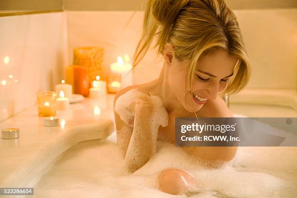 young woman taking a bath - bubble bath foto e immagini stock