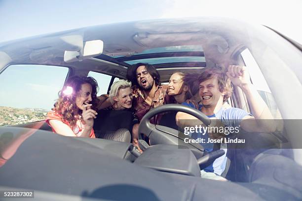 friends singing in a car - auto interieur stockfoto's en -beelden
