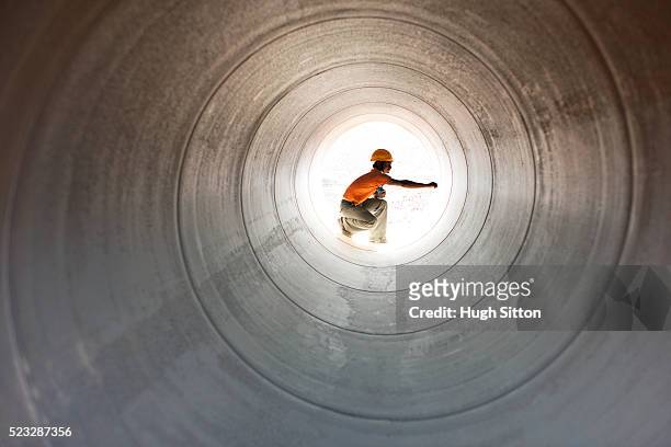 construction worker inspecting pipeline in desert - pipeline stockfoto's en -beelden