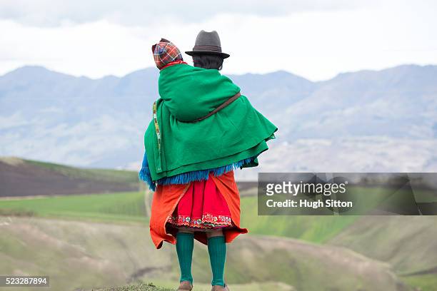 traditionally dressed woman carrying her child, ecuador - ecuador fotografías e imágenes de stock