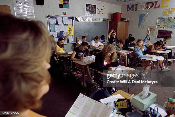 students raising their hands in class - archival classroom stock pictures, royalty-free photos & images