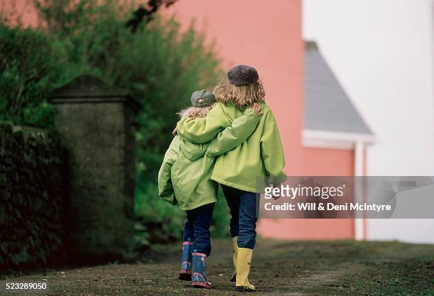 sisters walking arm in arm - irish family stock pictures, royalty-free photos & images