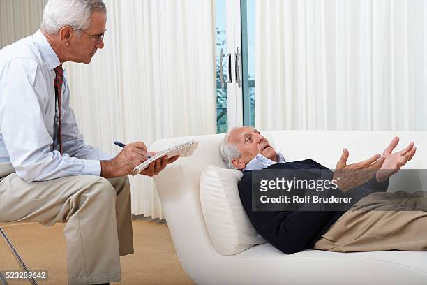 psychiatrist treating senior man - psychiatrists couch fotografías e imágenes de stock