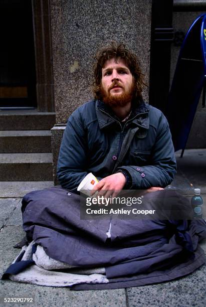 homeless person sitting on pavement - homelessness stock pictures, royalty-free photos & images