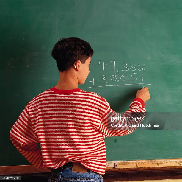 boy with hearing aid doing math on board - assistive technology student stock pictures, royalty-free photos & images