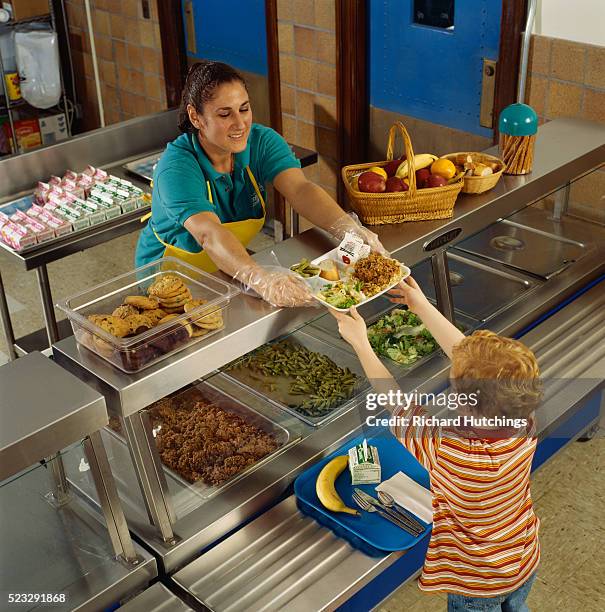 boy getting food in the cafeteria - cafeteria stock pictures, royalty-free photos & images