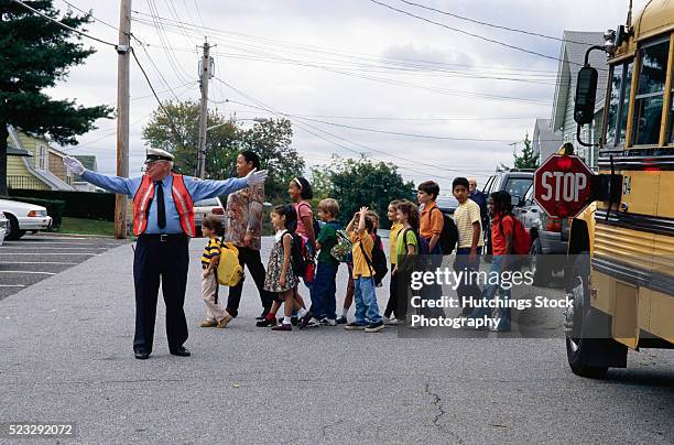 children crossing the street - traffic police officer fotografías e imágenes de stock