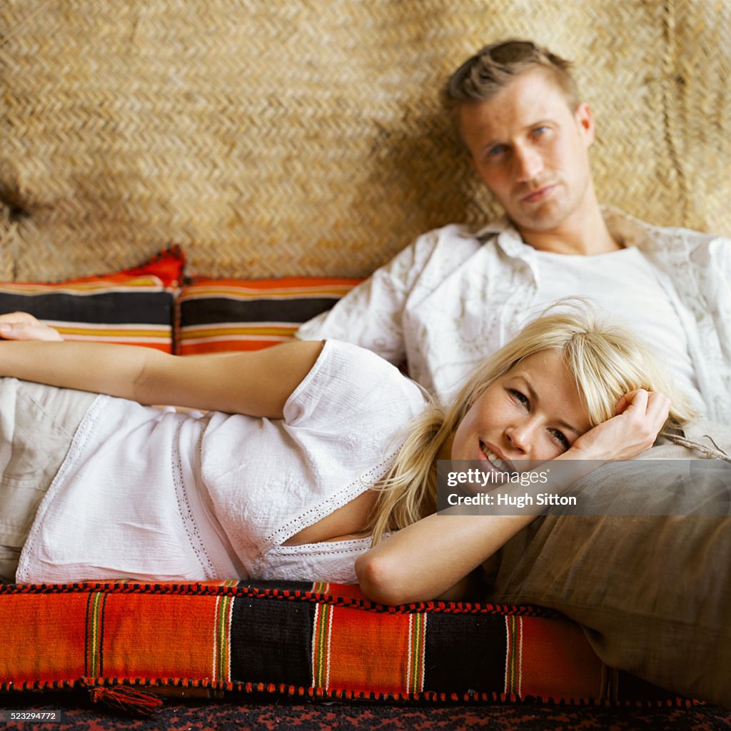 Couple Relaxing in a Tent with Cushions