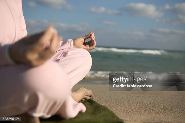 mature woman practicing yoga on beach - ギアナ・ムドラー ストックフォトと画像