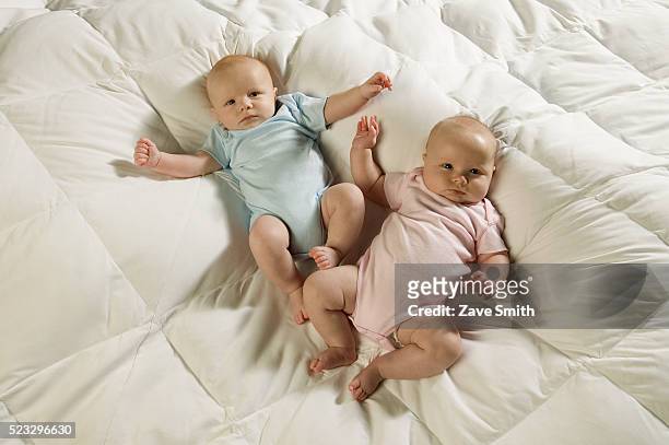 twin babies on bed - twin boys stock pictures, royalty-free photos & images