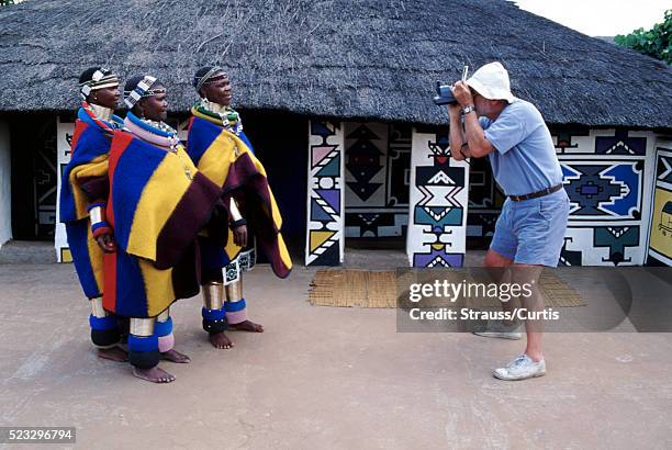 tourist taking pictures of ndebele women - ndebele village stockfoto's en -beelden