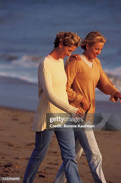 lesbian couple strolling on the beach - archival gay stock pictures, royalty-free photos & images