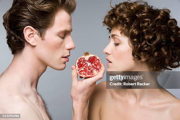 couple eating pomegranate - afrodisíaco fotografías e imágenes de stock