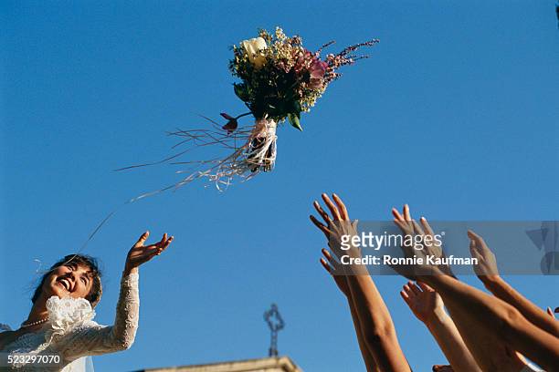 bride throwing bouquet - feierliche veranstaltung stock-fotos und bilder