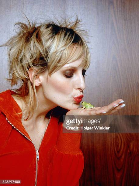 young woman kissing frog - woman frog hand stockfoto's en -beelden