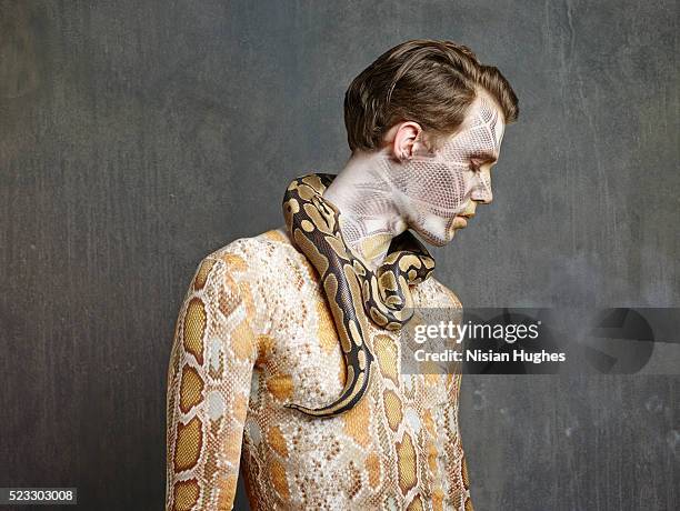 man with snake makeup and snake - piel de serpiente fotografías e imágenes de stock