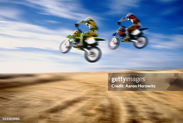 motocross riders jumping over dunes - moto vintage stock-fotos und bilder