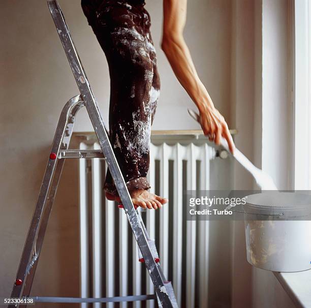 man standing on ladder painting - dirty feet stock-fotos und bilder