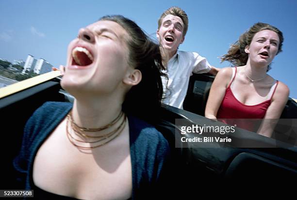 friends riding roller coaster - rollercoaster stock-fotos und bilder