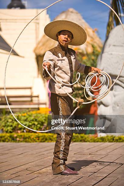 hispanic charrito twirling a lasso - mexican cowboy stock pictures, royalty-free photos & images