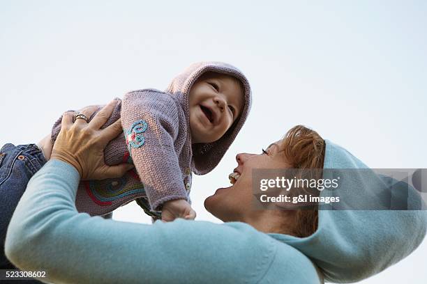 mother lifting child - eltern baby hochheben stock-fotos und bilder