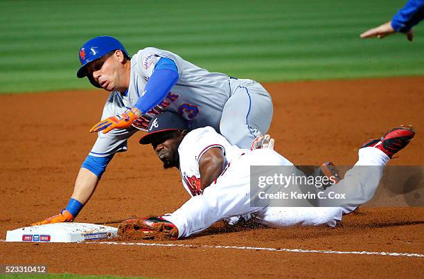 Asdrubal Cabrera of the New York Mets slides safely onto third base over top of Adonis Garcia of the Atlanta Braves on a throwing error by Bud Norris...