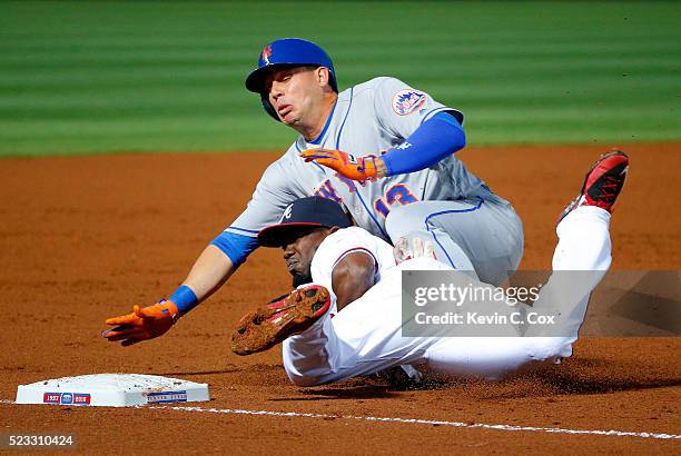 Asdrubal Cabrera of the New York Mets slides safely onto third base over top of Adonis Garcia of the Atlanta Braves on a throwing error by Bud Norris...