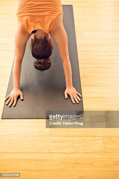 yoga student in downward facing dog pose - downward facing dog position stock pictures, royalty-free photos & images