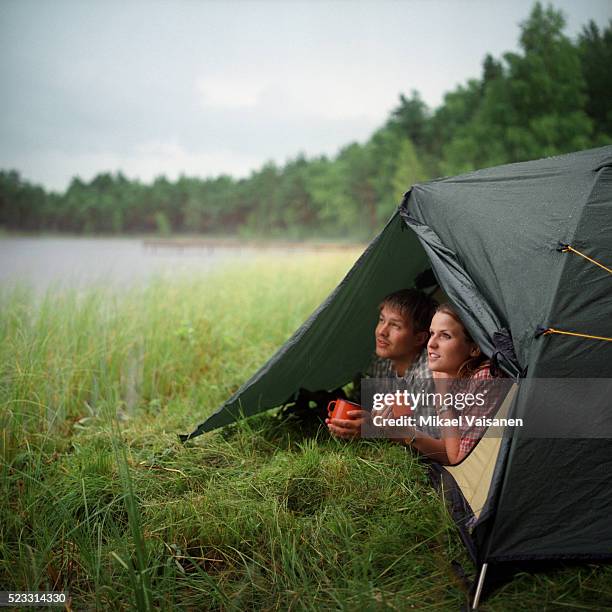 young couple in tent by lake - camping stock pictures, royalty-free photos & images