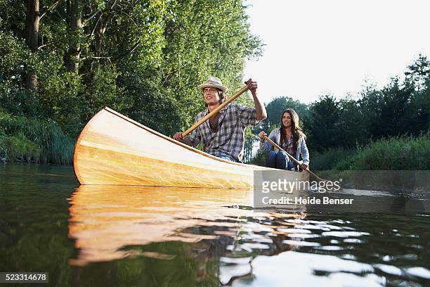 couple canoeing on a river - piragüismo fotografías e imágenes de stock