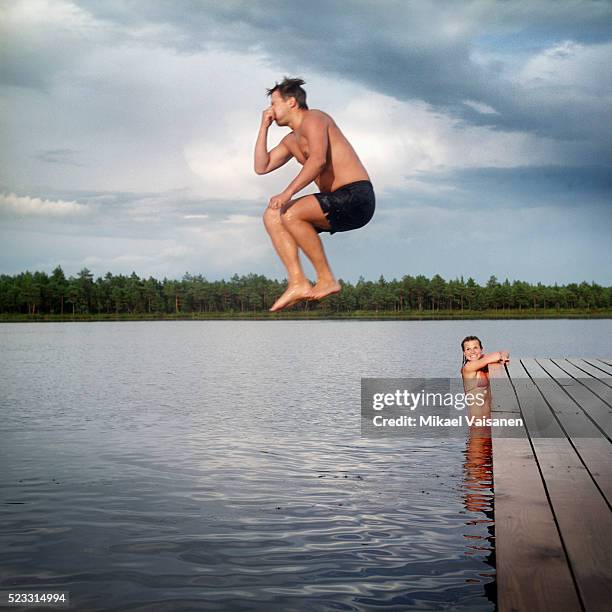 man jumping into lake - 鼻をつまむ ストックフォトと画像