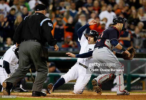 Ian Kinsler of the Detroit Tigers scores from first base against catcher Yan Gomes of the Cleveland Indians to tie the game at 1-1 as home plate...