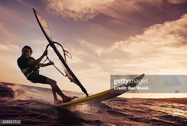 man windsurfing on ocean - wind surfing stock pictures, royalty-free photos & images