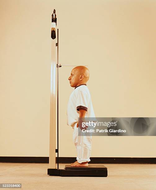 little person measuring his height - dwarf stockfoto's en -beelden