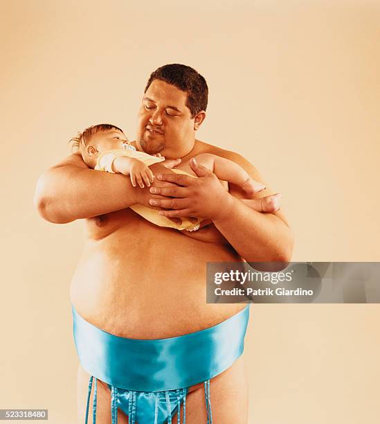 sumo wrestler holding infant - sumo stock-fotos und bilder